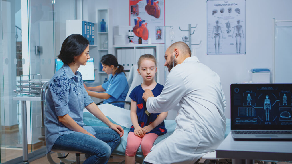 Little girl having annual medical check-up, doctor using stethoscope. Healthcare practitioner physician specialist in medicine providing health care services consultation treatment in hospital